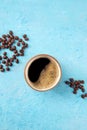 Coffee cup and beans, shot from above on a blue background Royalty Free Stock Photo