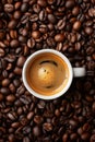 Coffee cup with coffee beans top view. Cup of freshly brewed espresso closeup on roasted coffee beans background Royalty Free Stock Photo