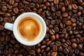 Coffee cup with coffee beans top view. Cup of freshly brewed espresso closeup on roasted coffee beans background Royalty Free Stock Photo