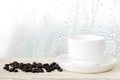 Coffee cup and beans on wood table over blurred tree background Royalty Free Stock Photo