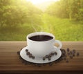 Coffee cup and beans on a wooden table. background orange trees with fruits in sun light Royalty Free Stock Photo
