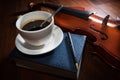 Coffee cup with book,pen and violin.