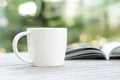 Coffee cup with book on wood table with blur bokeh background Royalty Free Stock Photo