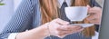 Coffee cup in businesswoman`s hand. Young woman working with documents and laptop close-up. Royalty Free Stock Photo