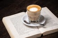 Coffee cup cappuccino hot latte or coffee with milk in a glass cup, open book