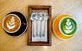 Coffee cup cappuccino w ith latte art, coffee spoon and matcha green tea latte cup on wooden kitchen table in coffee cafe shop. Royalty Free Stock Photo