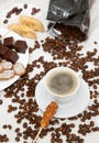 The coffee cup with caramel stick and dish of sweets Royalty Free Stock Photo