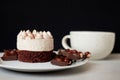 Coffee cup and chocolate cake on a white plate on a black background Royalty Free Stock Photo