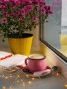 Coffee cup chocolate notebook beautiful pink autumn Chrysanthemum flowers in yellow pot on window. Cozy home Royalty Free Stock Photo