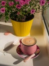 Coffee cup chocolate notebook beautiful pink autumn Chrysanthemum flowers in yellow pot on window. Cozy home Royalty Free Stock Photo