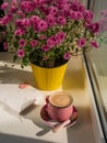 Coffee cup chocolate notebook beautiful pink autumn Chrysanthemum flowers in yellow pot on window. Cozy home Royalty Free Stock Photo