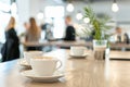 Coffee cup close-up on the table. Coffee break in business meeting or cafe. Cappuccino cup on the table. People in the blurred