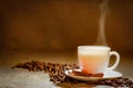 Coffee cup and coffee beans on a wooden table and sack background, Vintage color tone Royalty Free Stock Photo