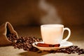 Coffee cup and coffee beans on a wooden table and sack background, Vintage color tone Royalty Free Stock Photo