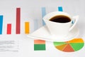 Coffee cup with colorful bar and pie charts Royalty Free Stock Photo