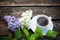 Coffee cup and colorful lilac flowers on wooden background Royalty Free Stock Photo