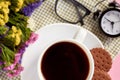 Coffee cup with cookies, alarm clock, flowers, mascara, on pink background composition Royalty Free Stock Photo