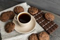 Coffee cup with cookies and chocolate on wooden table background. Mug of black coffee with chocolate cookies. Fresh