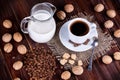 Coffee cup, cream, walnuts and cane sugar Royalty Free Stock Photo