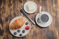 Coffee cup, croissant with berries in white bowl and butter knife on wooden table. Top view. Healthy breakfast with fresh berries Royalty Free Stock Photo