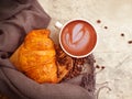 Coffee cup, croissant on wooden background bakery