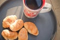 Coffee in a cup and croissants on a plate. Food and drinks. Plate on a wooden background