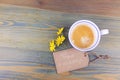 Coffee cup and daisy flowers with wish cardboard label on wooden table. Have a nice day romantic message.