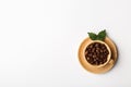 Coffee cup filled with coffee beans and green fresh leaves Royalty Free Stock Photo