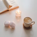 coffee cup, flower, candle and a book on a white table background top view. minimal home interior decor Royalty Free Stock Photo