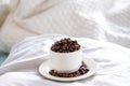 Coffee cup full of coffee beans on sleeping pillow with quilt Royalty Free Stock Photo