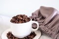 Coffee cup full of coffee beans on sleeping pillow with quilt in white color Royalty Free Stock Photo