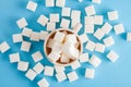 Coffee cup full of sugar cubes isolated on pastel blue background Royalty Free Stock Photo