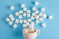 Coffee cup full of sugar cubes isolated on pastel blue background Royalty Free Stock Photo
