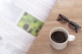 Coffee cup and glasses on wood table with blur newspaper reading news and drink coffee on morning to be informed of virus Royalty Free Stock Photo