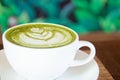 Coffee cup with Green Matcha latte art foam on wood table in coffee shop with copy space.Coffee is one of the most popular Royalty Free Stock Photo