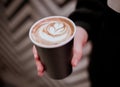 Coffee cup in hands, with latte-art Royalty Free Stock Photo