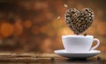 Coffee cup with a heart from coffee beans on wooden table Royalty Free Stock Photo
