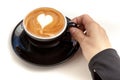 Coffee cup with heart shape latte art on top, hand holding the c Royalty Free Stock Photo