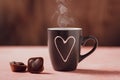 Coffee cup with heart and two heart shaped chocolates on wooden background. Royalty Free Stock Photo