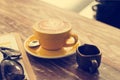 Coffee cup and honey syrup in coffee shop on wooden table