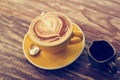 Coffee cup and honey syrup on wooden background