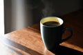 Coffee cup with hot steam on brown wood table. Healthy black coffee in a mug. Royalty Free Stock Photo