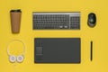 Coffee Cup, keyboard, mouse and graphic tablet on a yellow background.