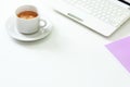 Coffee cup, laptop and lavender notpad on white table. Selective focus