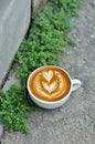 Coffee cup with latte art on the concrete floor Royalty Free Stock Photo