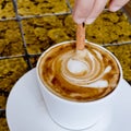 A coffee cup Latte being stirred by Cinnamon sticks. Royalty Free Stock Photo