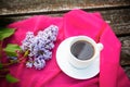 Coffee cup and lilac flowers on wooden background Royalty Free Stock Photo