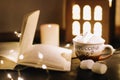 Coffee cup with marshmallows and a book on the table. Still life on dark background, flat lay Royalty Free Stock Photo