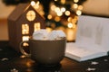 Coffee cup with marshmallows and a book on the table. Still life on dark background. Royalty Free Stock Photo