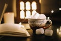 Coffee cup with marshmallows and a book on the table. Still life on dark background, flat lay Royalty Free Stock Photo